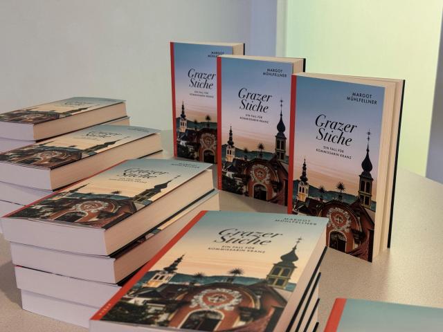 Mehrere Exemplare des Krimis "Grazer Stiche" werden auf einem Tisch präsentiert